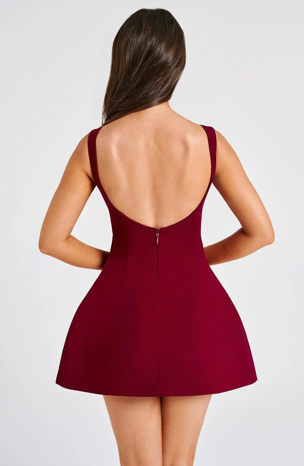 Back view burgundy mini dress with low scoop back, wide straps and center zipper, flared skirt