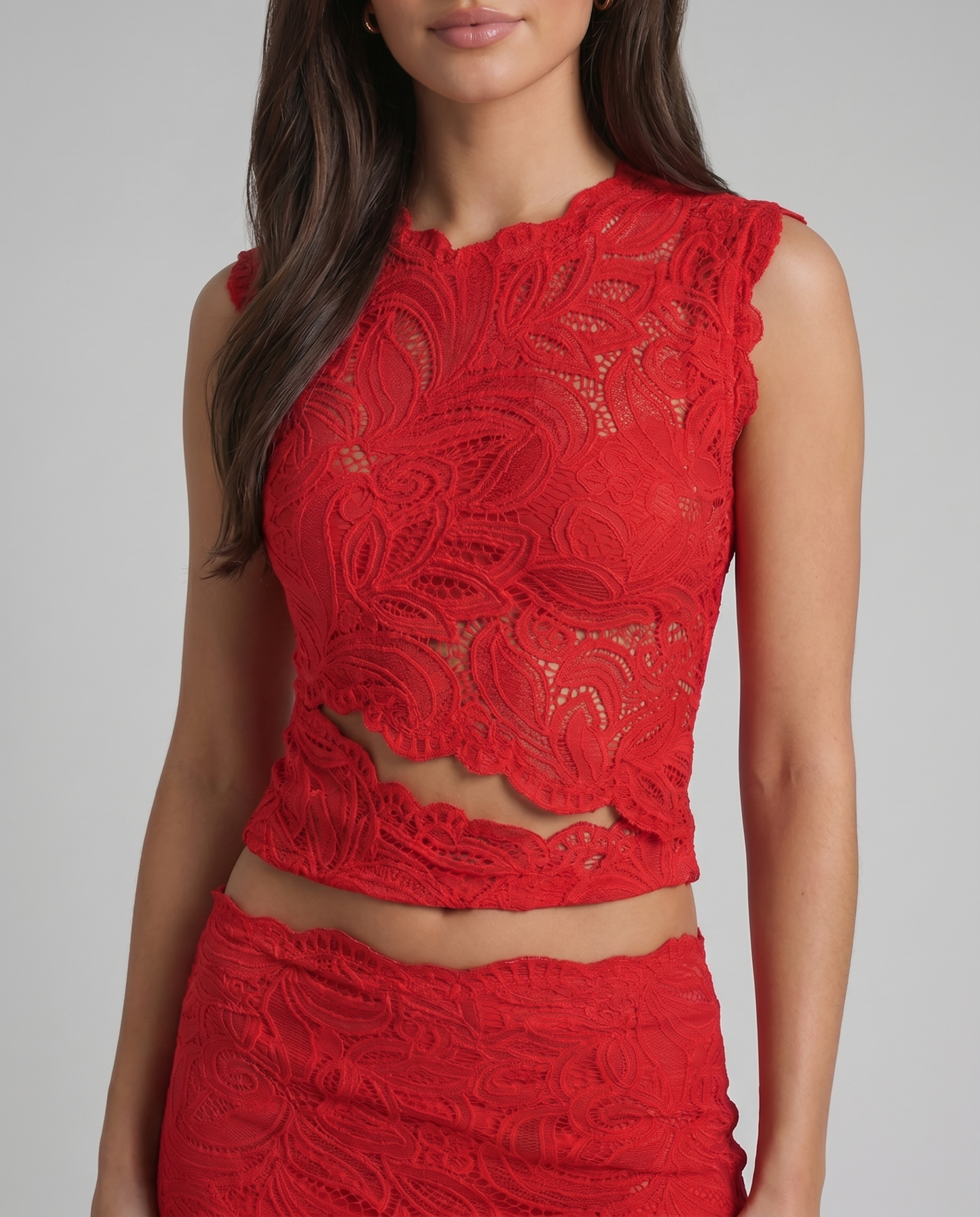 Close-up of red lace sleeveless crop top with floral pattern and scalloped waist band