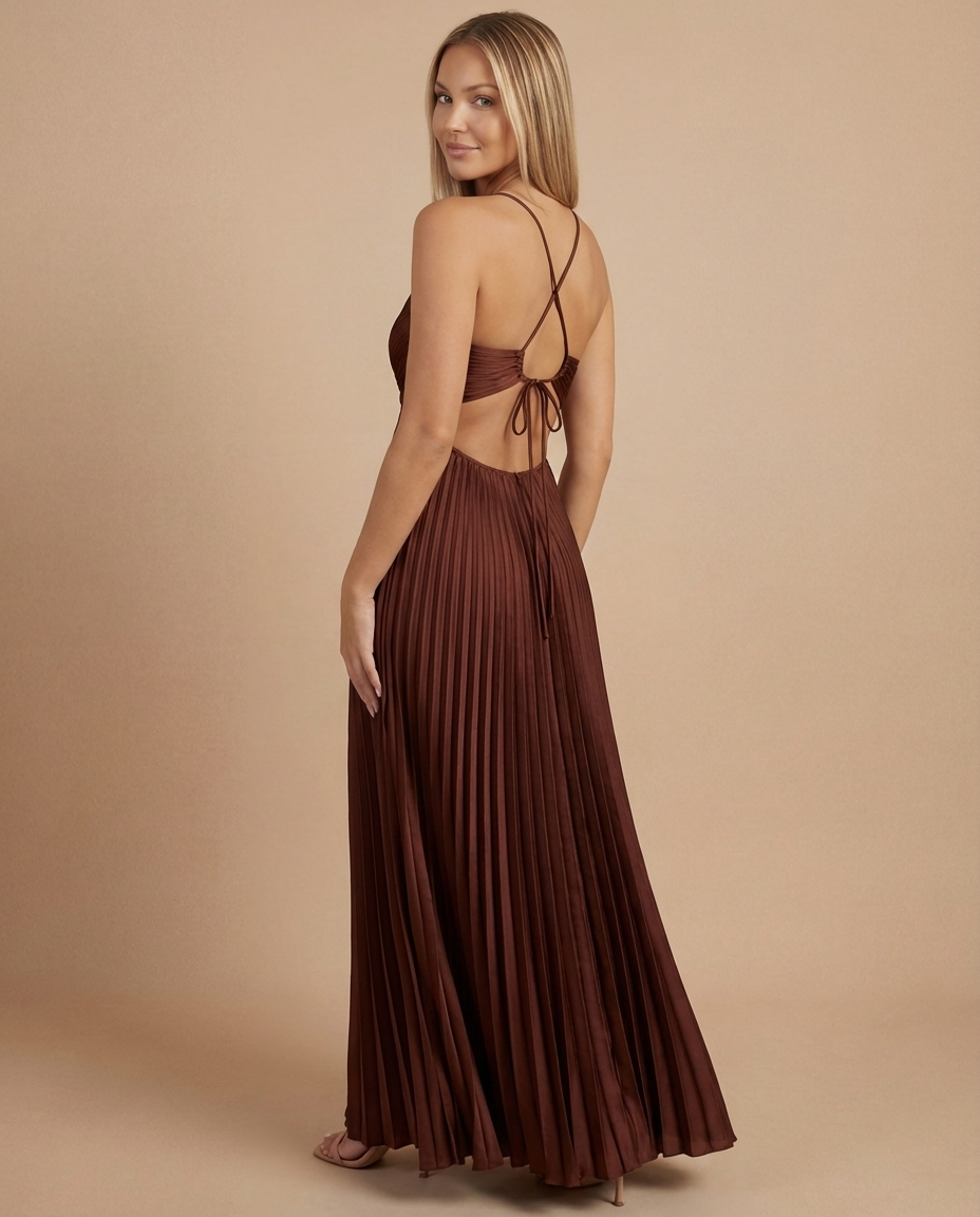 Three-quarter back angle of brown pleated maxi dress featuring open back tie and flowing pleated skirt