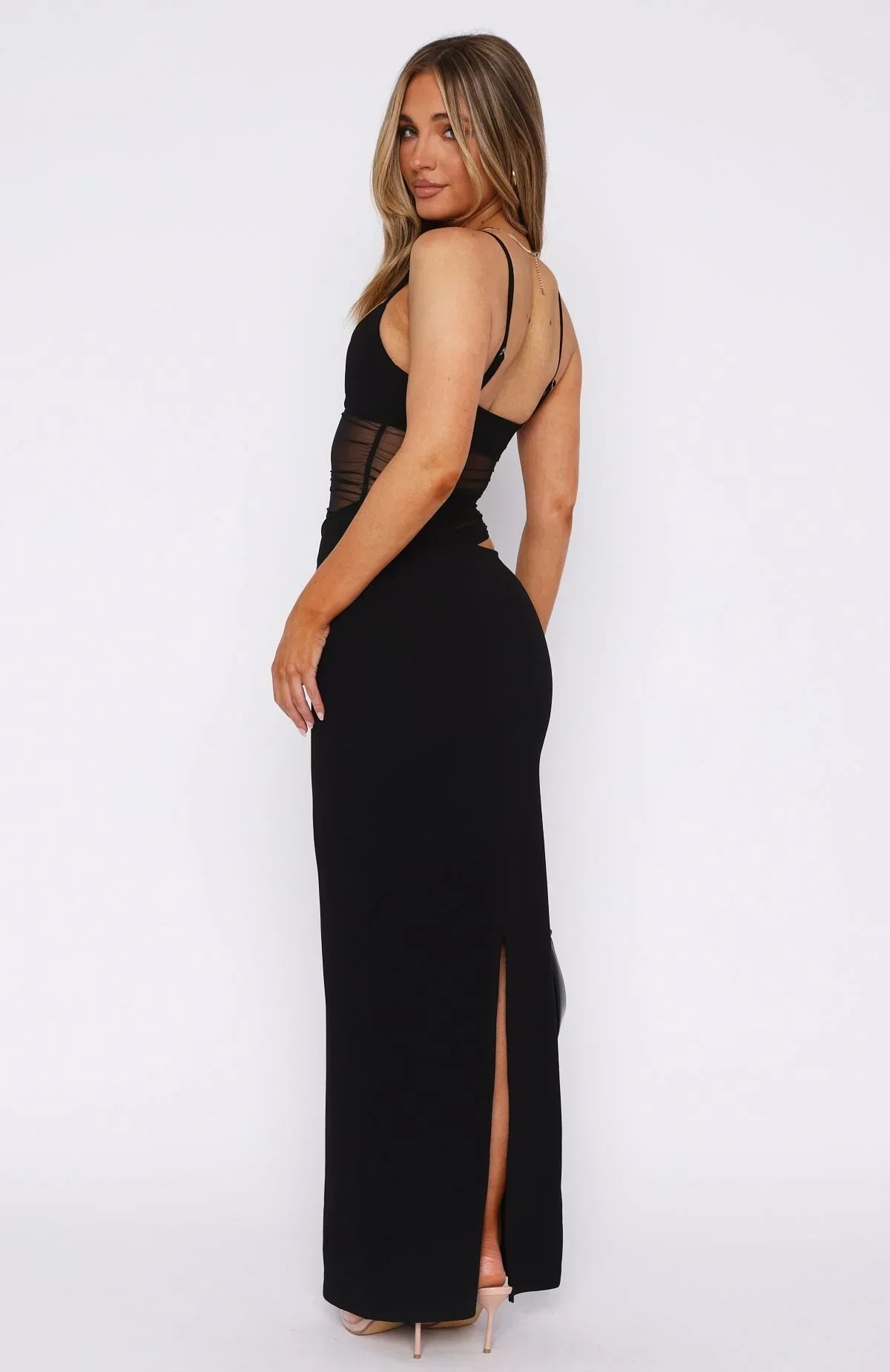 Back view of black maxi dress with strappy open back, sheer mesh waist detail and center back slit