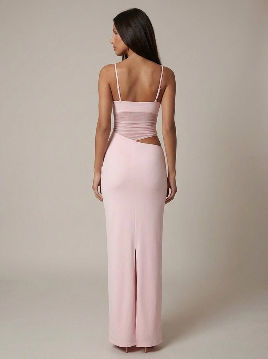 Back view of light pink maxi dress with adjustable straps, ruched bodice, side cutout and back slit