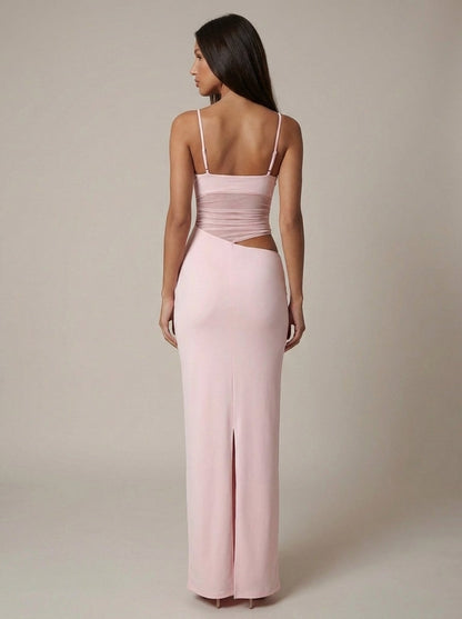 Back view of light pink maxi dress with adjustable straps, ruched bodice, side cutout and back slit