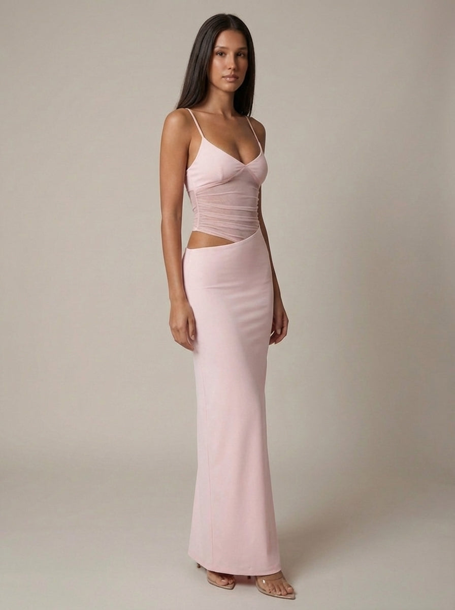 Three-quarter view of light pink maxi dress showing v-neck straps, ruched waist panel and asymmetrical cutout