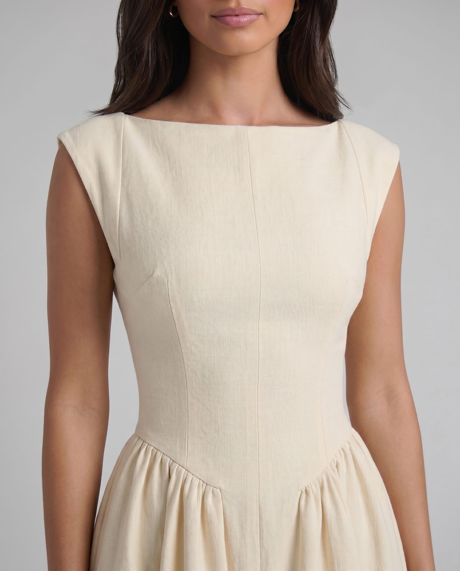 Close-up of white midi dress bodice with boat neckline, princess seams, and textured fabric