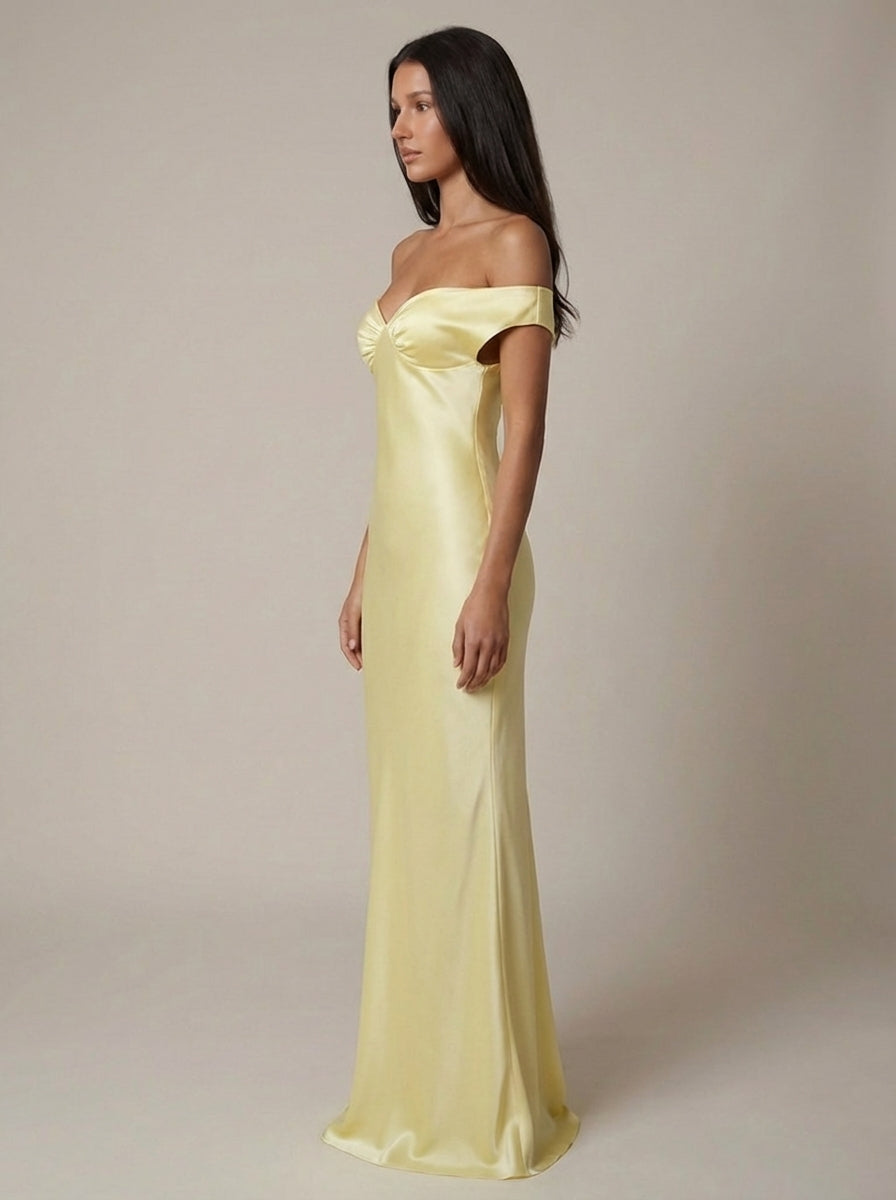 Side profile yellow satin maxi dress with off-shoulder sleeves and floor-length drape