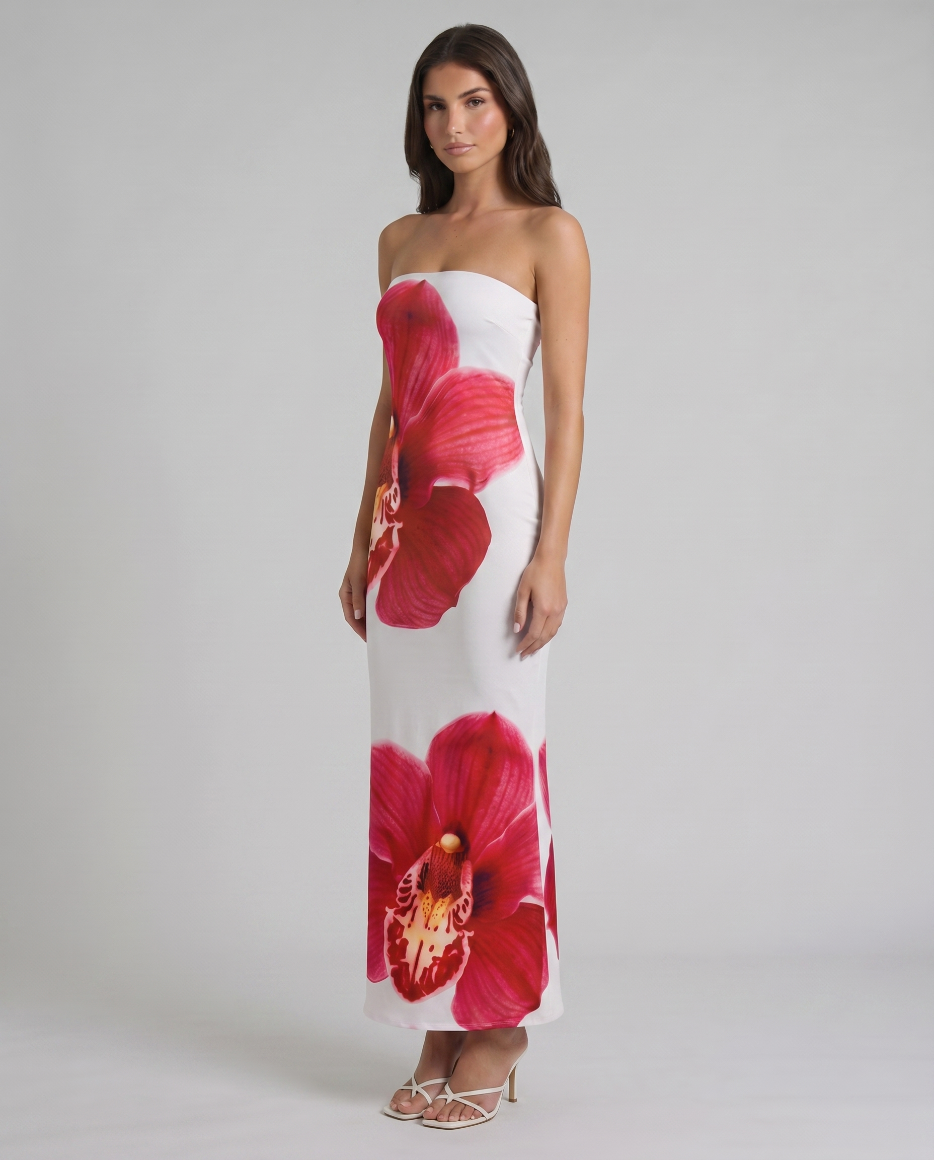 Angled view of strapless white and red floral maxi dress showing fitted silhouette and orchid print