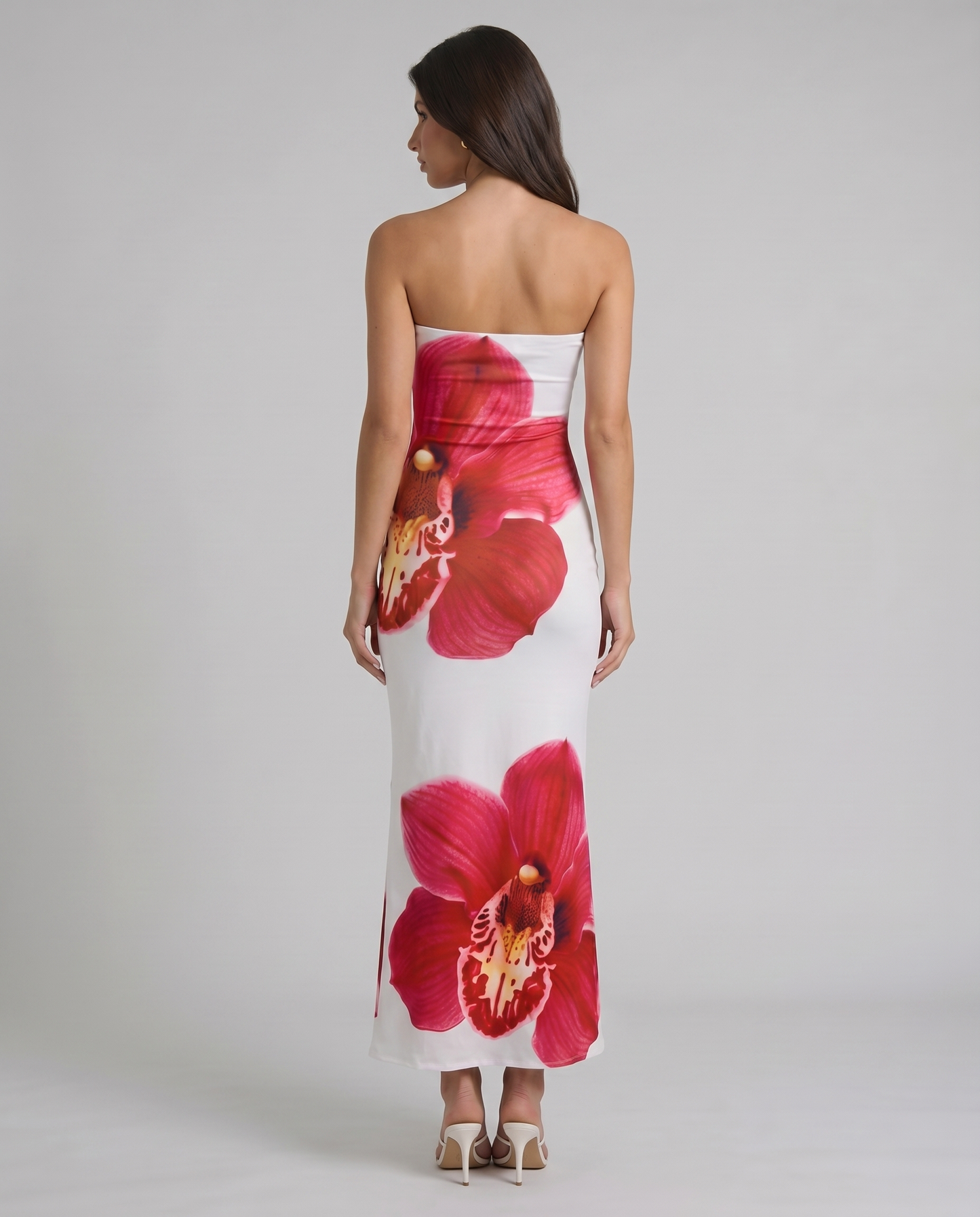 Back view of strapless white maxi dress with oversized red orchid print across bodice and skirt