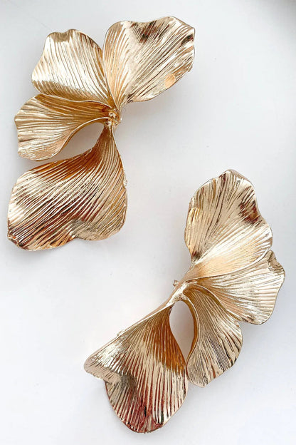Women gold sculptural leaf drop earrings with textured ridged finish
