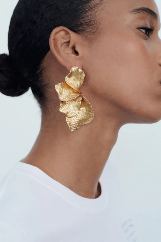 Women gold sculptural leaf drop earrings with textured ridged finish