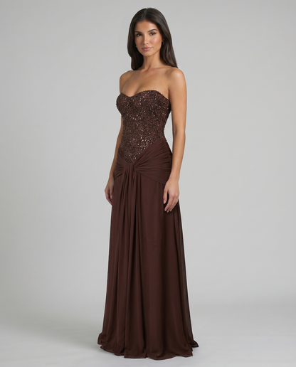 Three-quarter view brown maxi dress featuring strapless sequin bodice and gathered waist drape