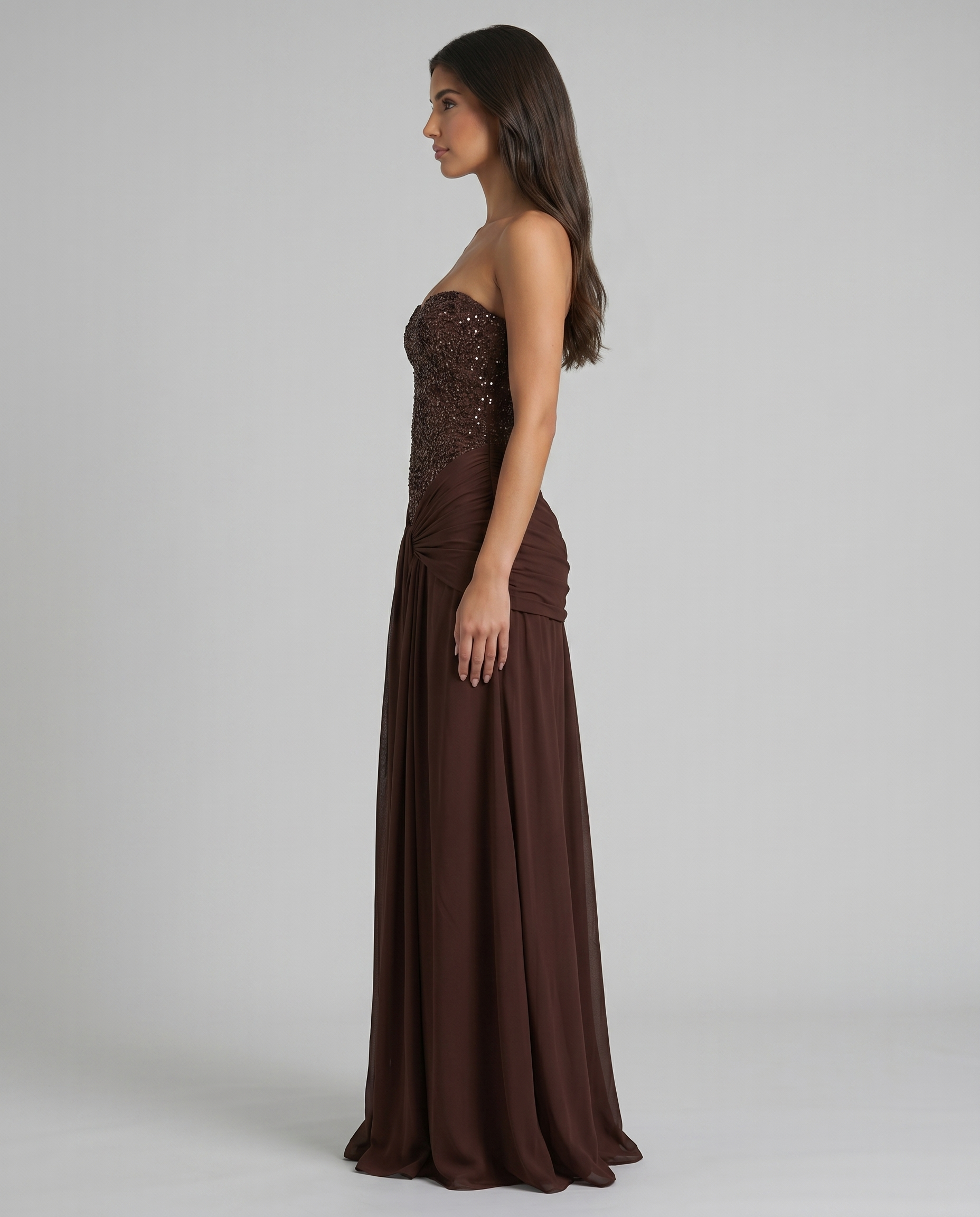 Side profile brown strapless maxi dress showing fitted beaded bodice and straight floor-length skirt