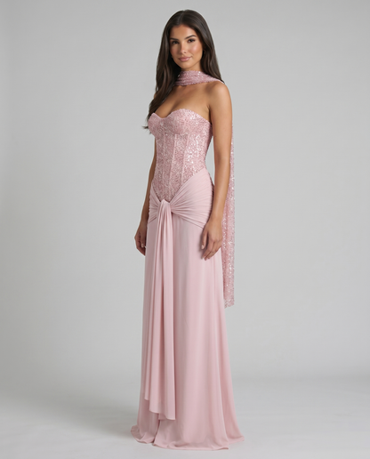 Three-quarter view of pink maxi dress with sparkly corset top, choker scarf detail, and ruched waist drape