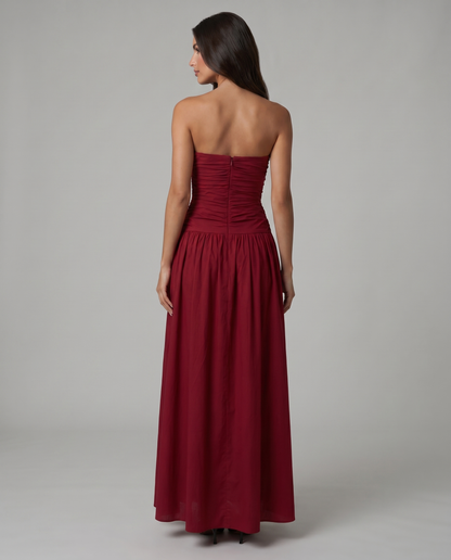 Back view of red strapless maxi dress showing center back zipper and gathered skirt