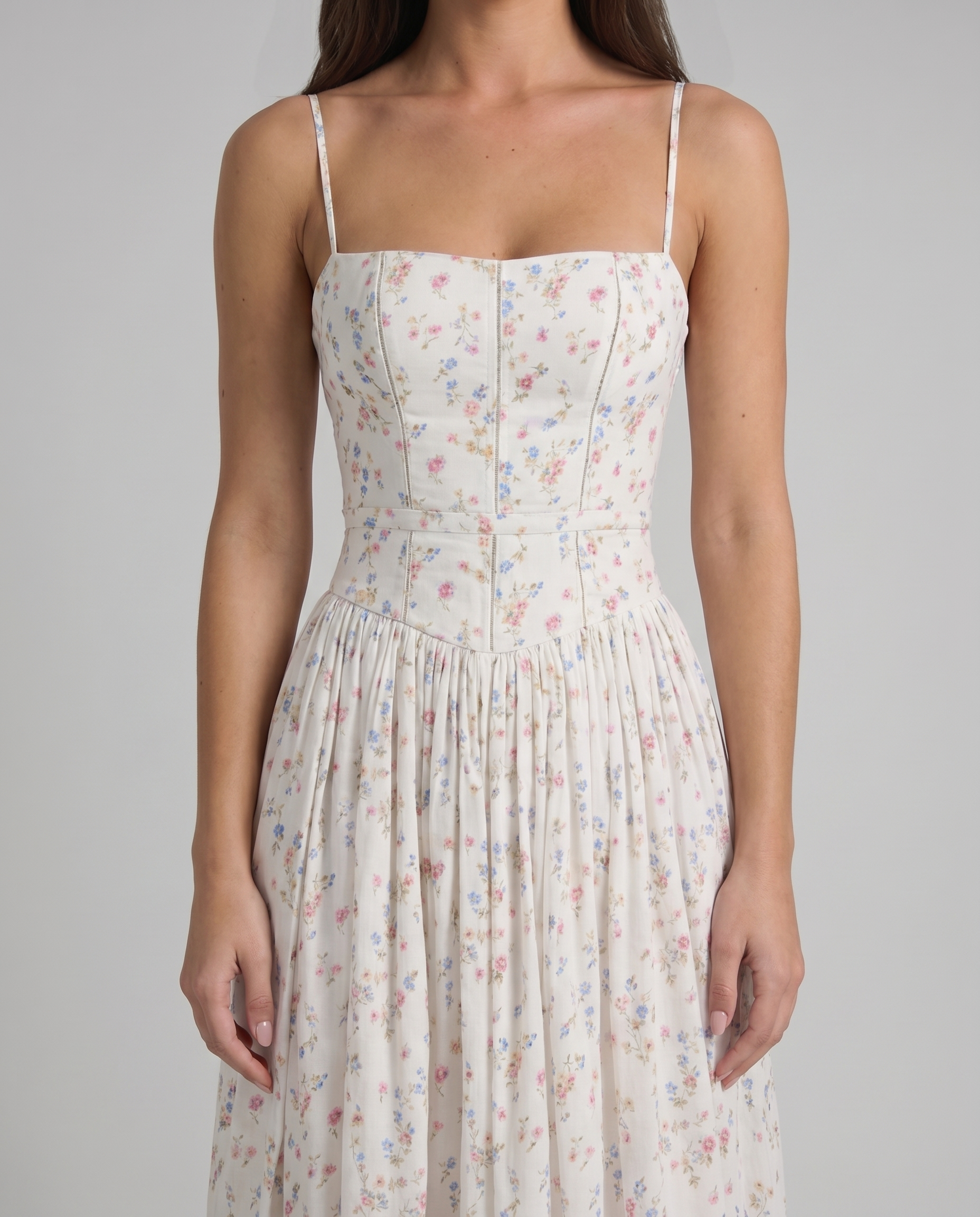 Close-up of cream floral midi dress bodice with straight neckline, seam detailing and thin straps