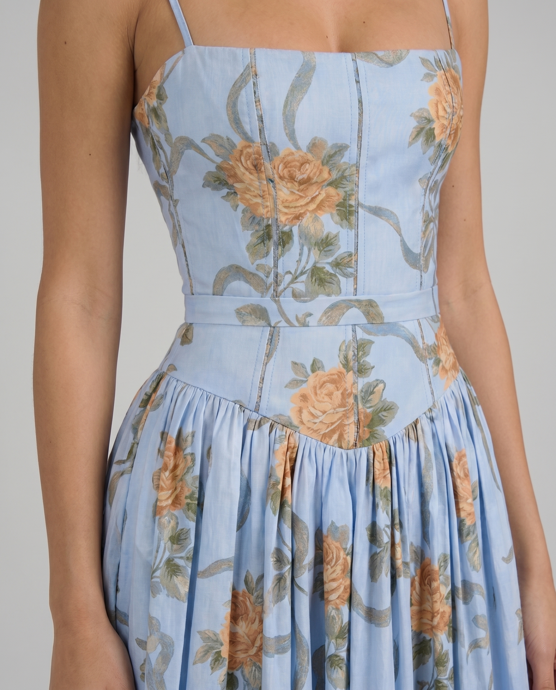 Close-up of square-neck corset bodice on blue floral midi dress with peach rose print