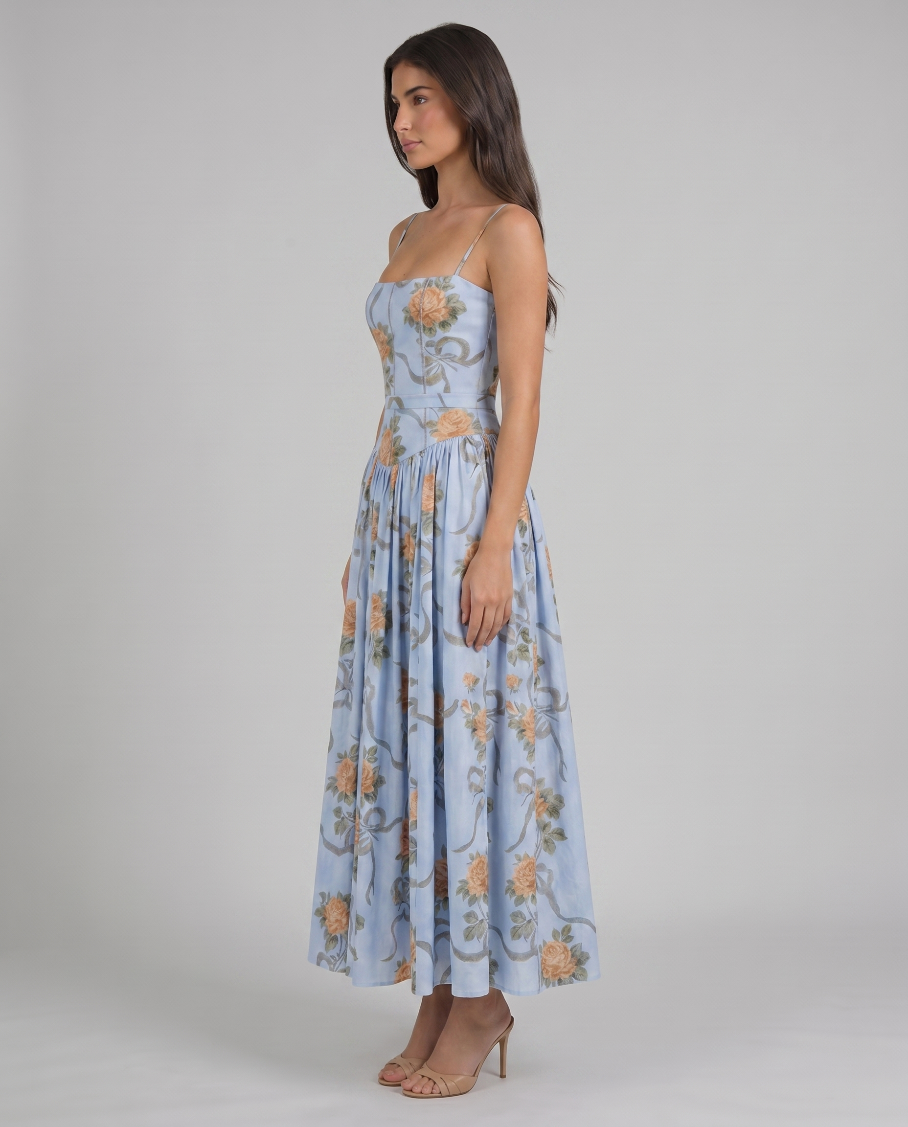 Angled front view of blue floral midi dress with peach roses, paneled bodice and slim straps