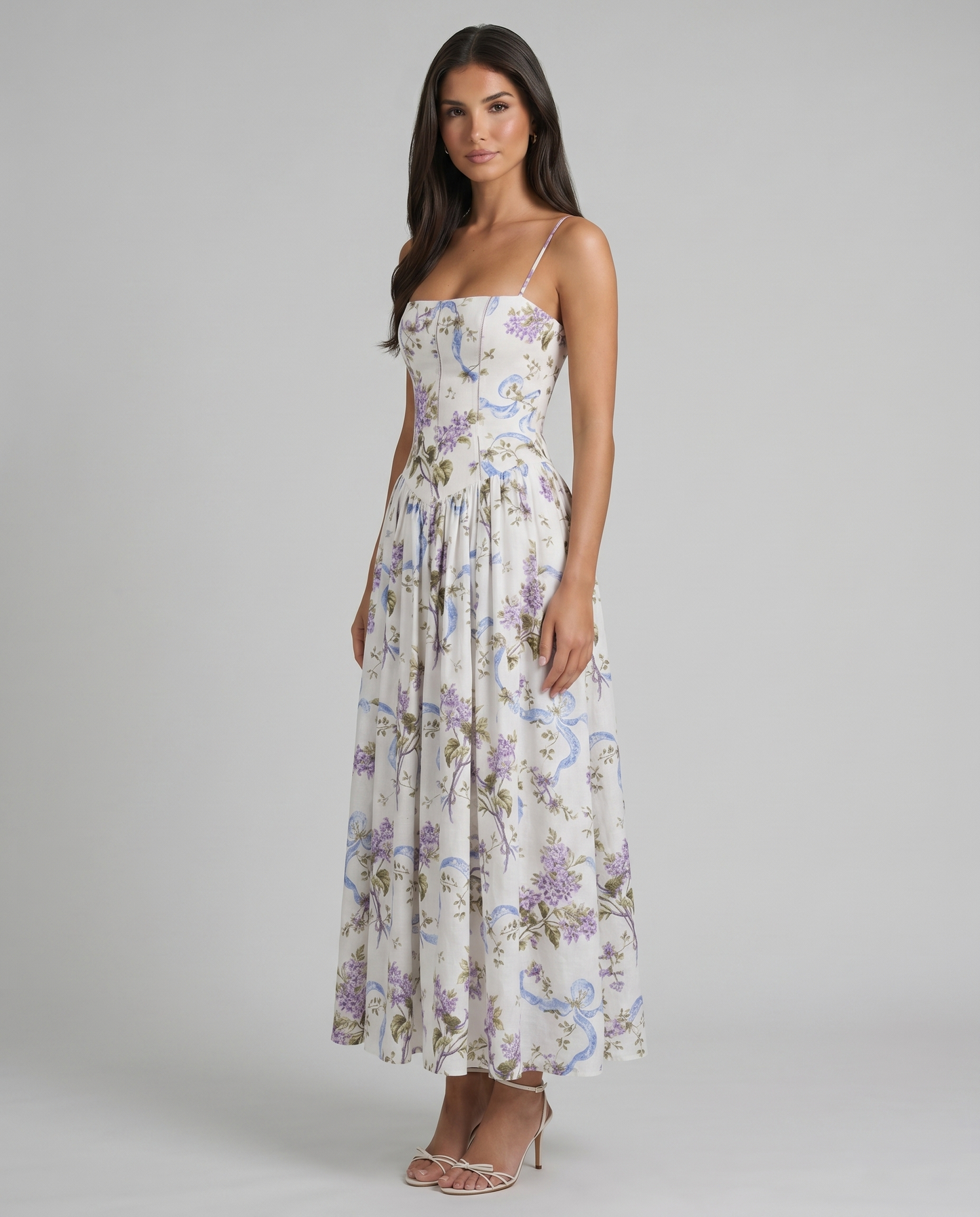 Three-quarter front view of purple floral midi dress with structured bodice, straps, and airy skirt