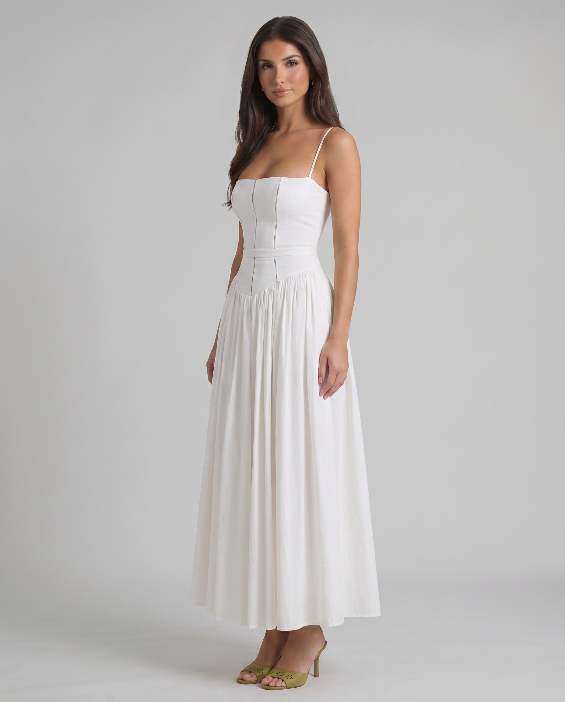 Three-quarter view of white midi dress showing fitted bodice, thin straps and flowing skirt drape