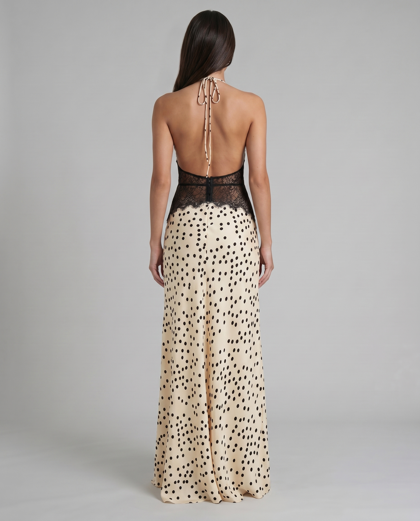 Back view black and white polka dot maxi dress with open back halter tie and lace waist panel