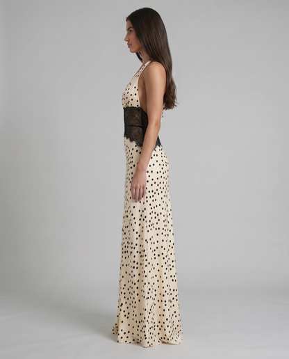 Side profile black and white polka dot maxi dress with halter top and fitted lace waist detail