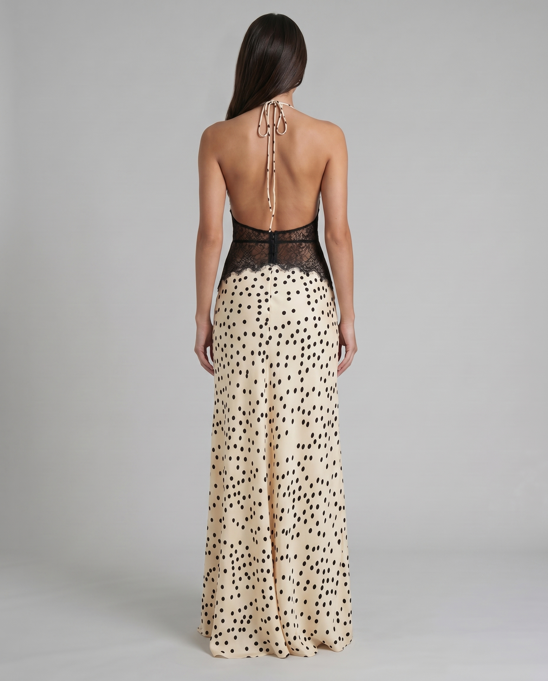 Back bodice detail showing open back, halter tie straps, and black lace waist on maxi dress