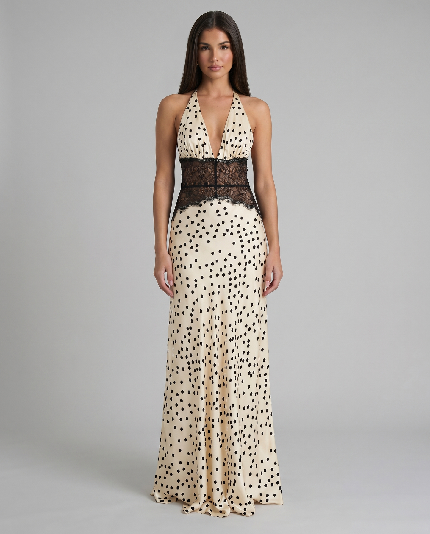 Front view black and white polka dot maxi dress with halter plunge neckline and lace waist