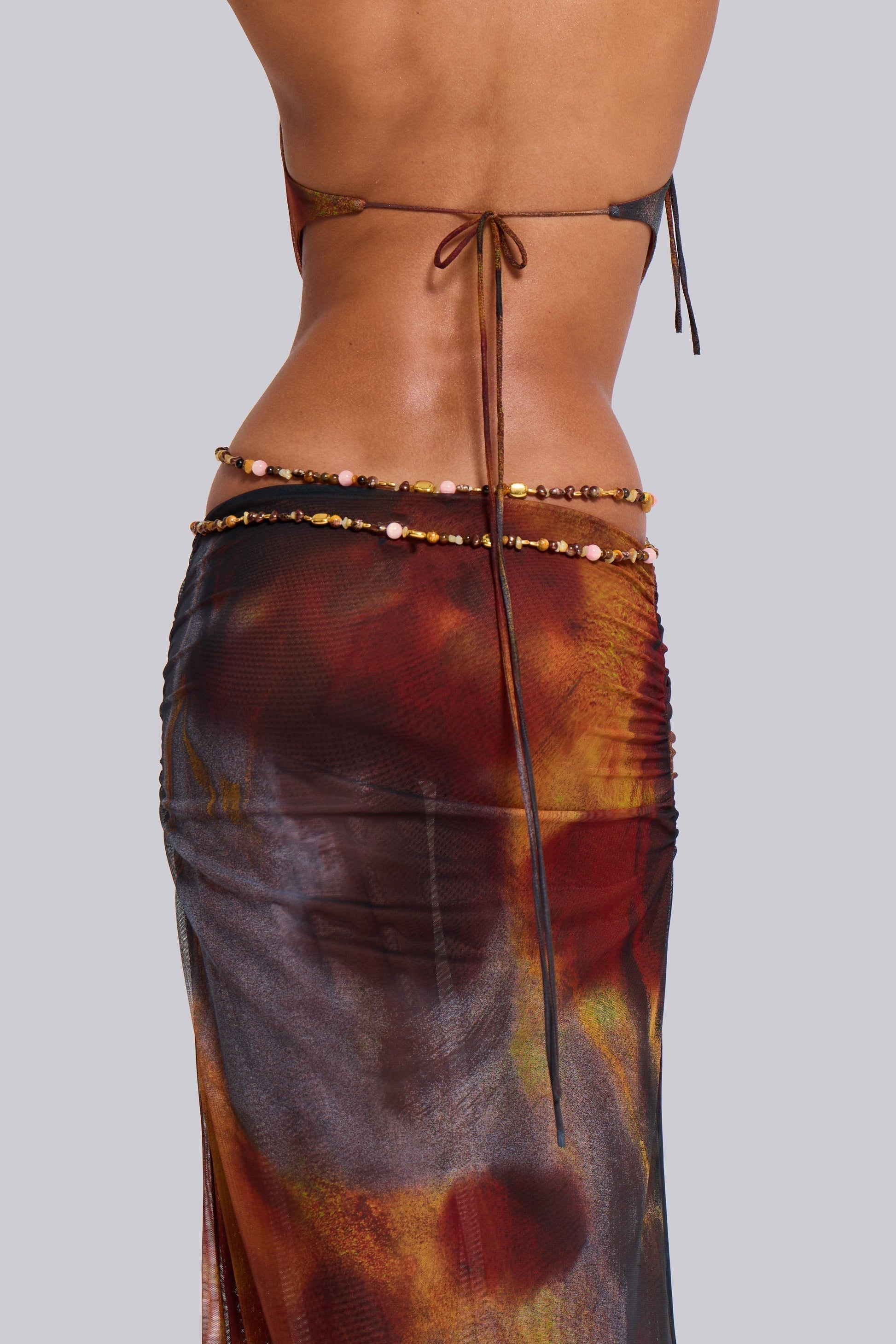 Rear detail showing tie-back halter straps and double beaded waist chain on multicolor maxi dress