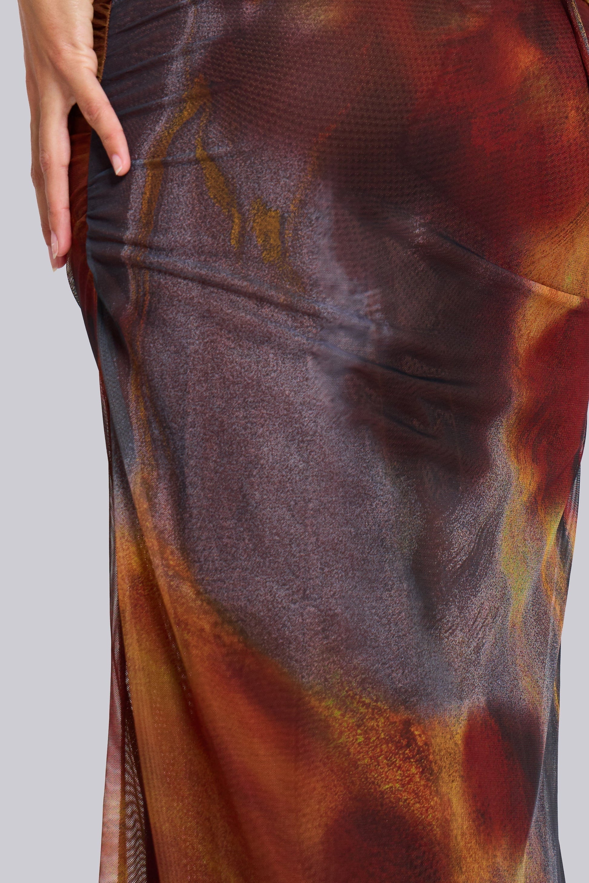 Zoomed detail of sheer mesh maxi dress material with blended multicolor pattern and subtle texture