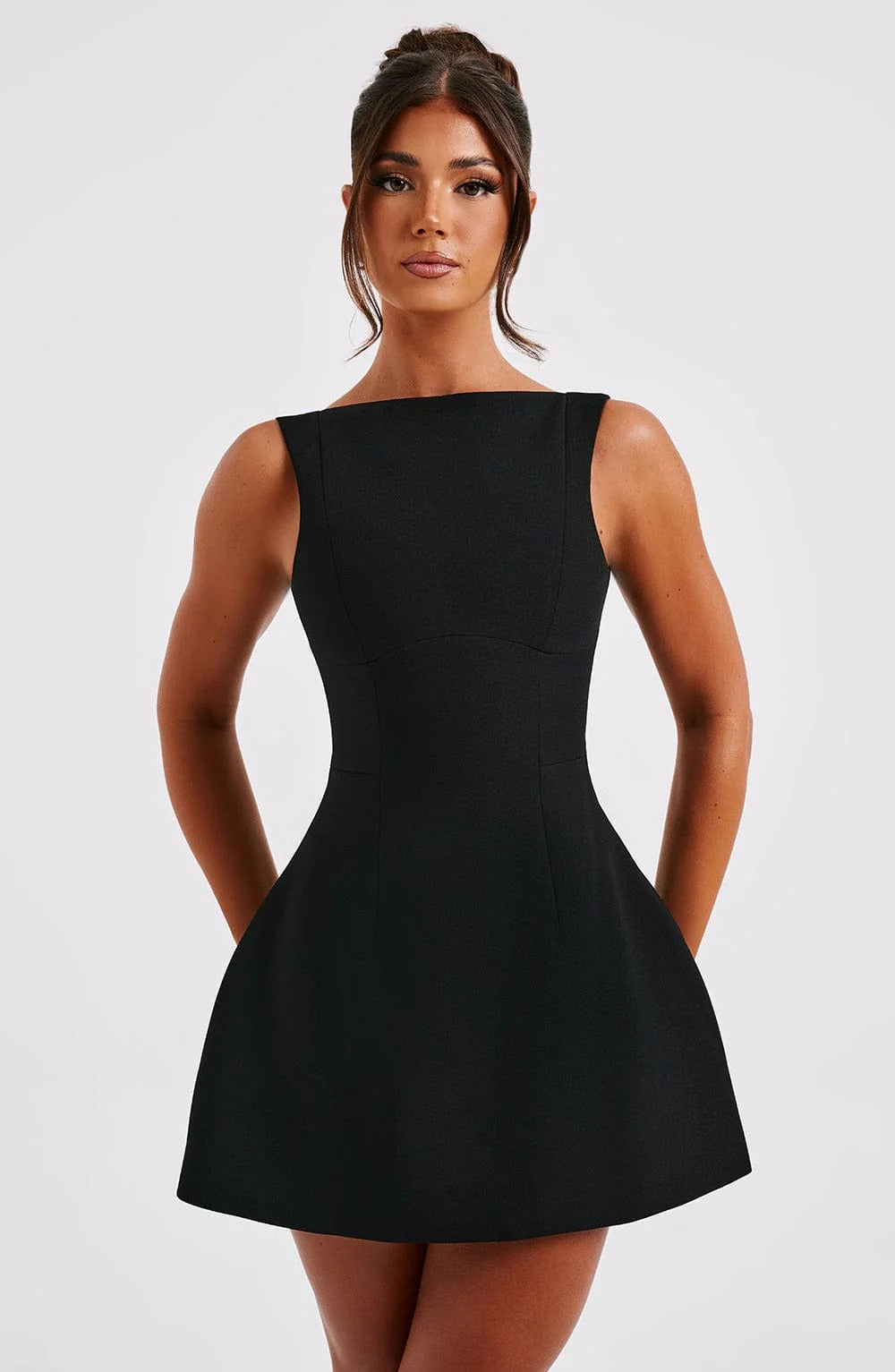 Black sleeveless mini dress with high neckline, fitted bodice and flared skirt, front view
