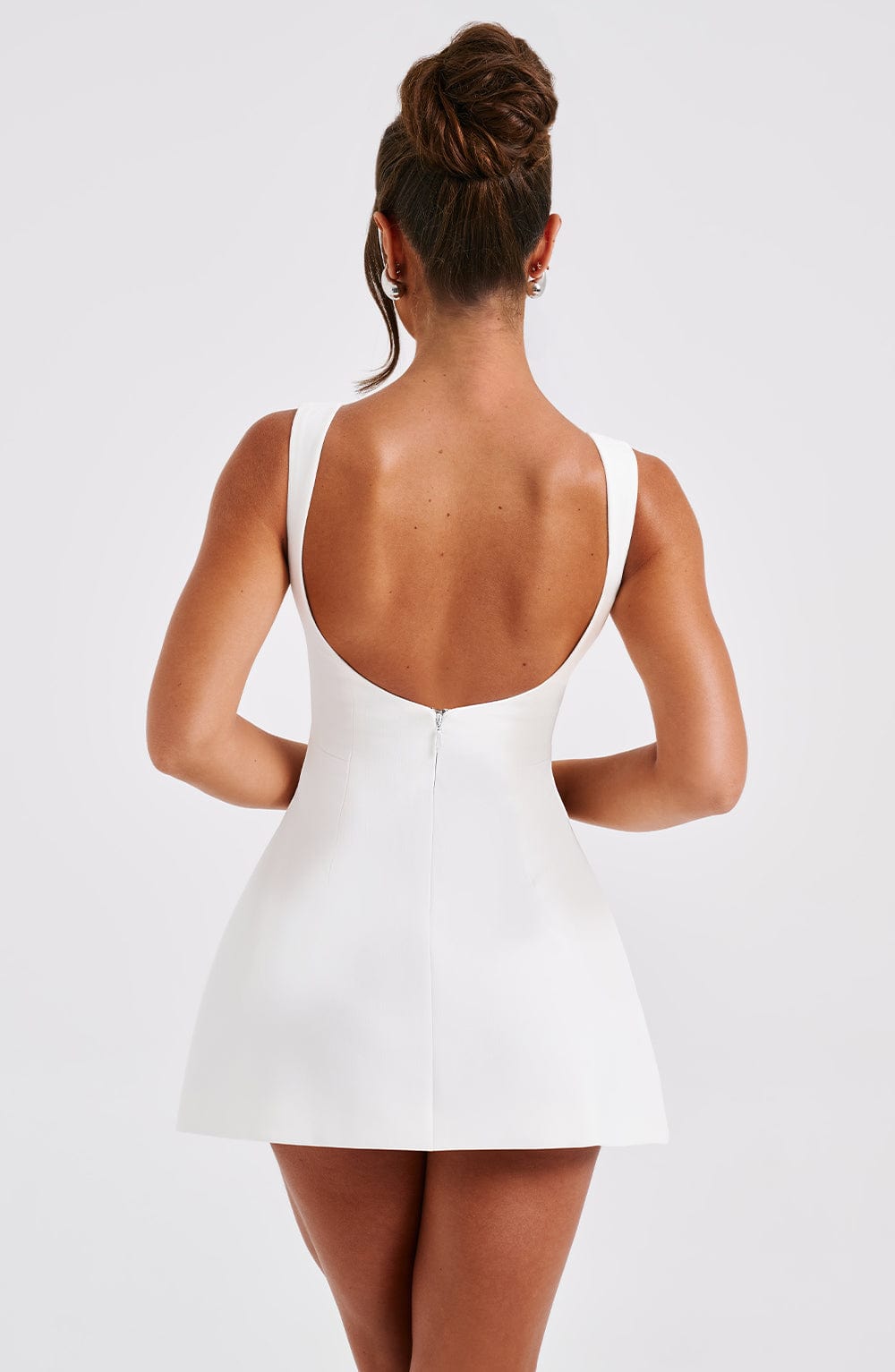 Back view of white mini dress with scoop back and center zipper, sleeveless A-line