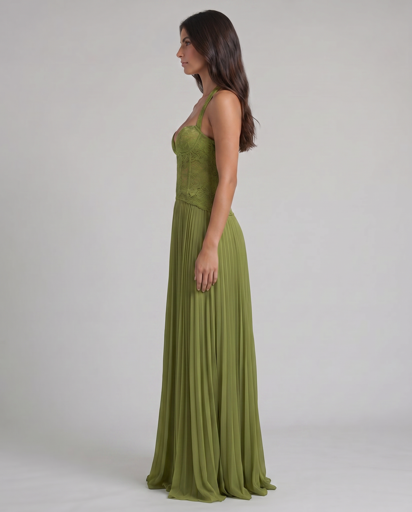 Side profile of green maxi dress with fitted lace corset top, halter straps, and soft pleated skirt