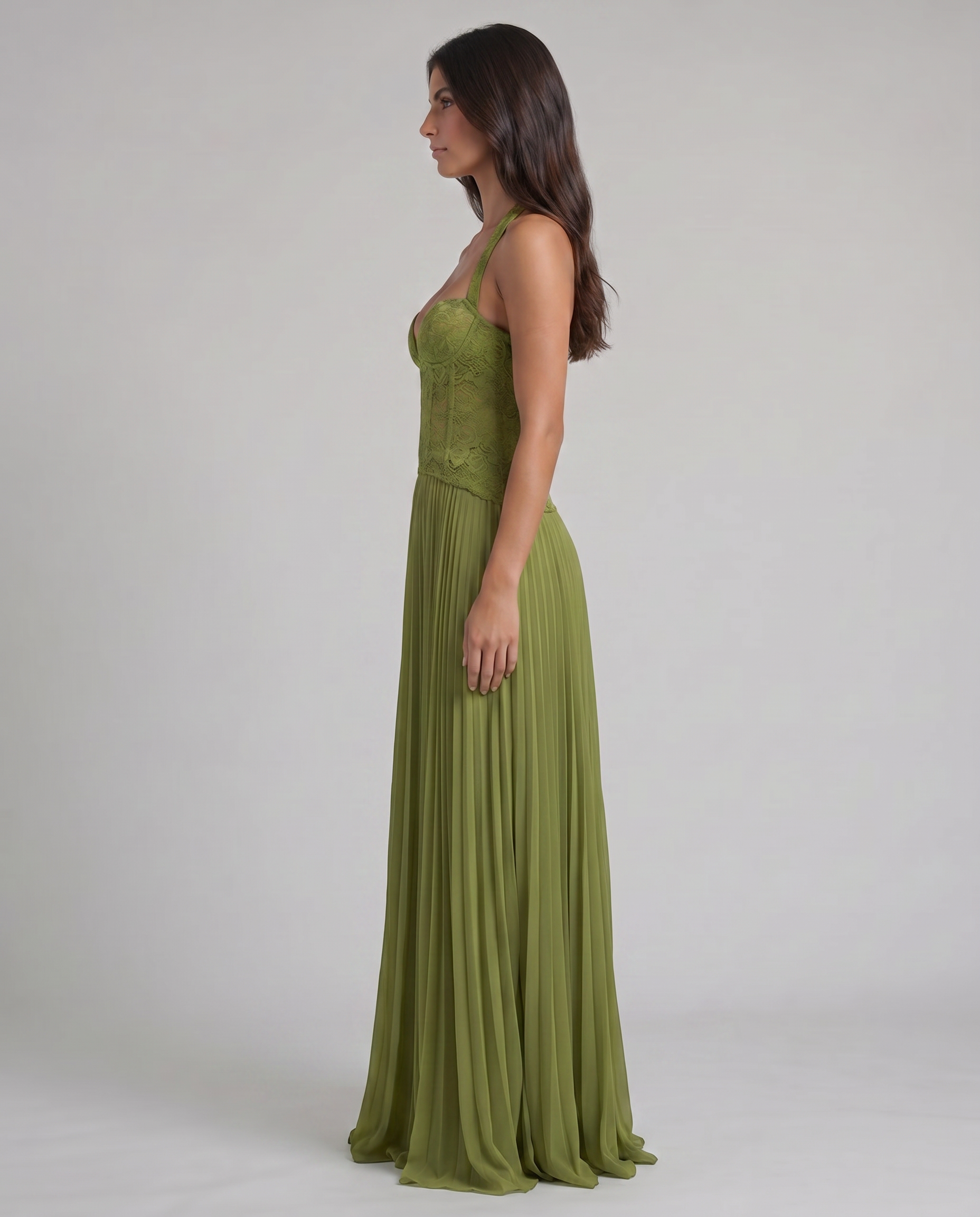 Side profile of green maxi dress with fitted lace corset top, halter straps, and soft pleated skirt