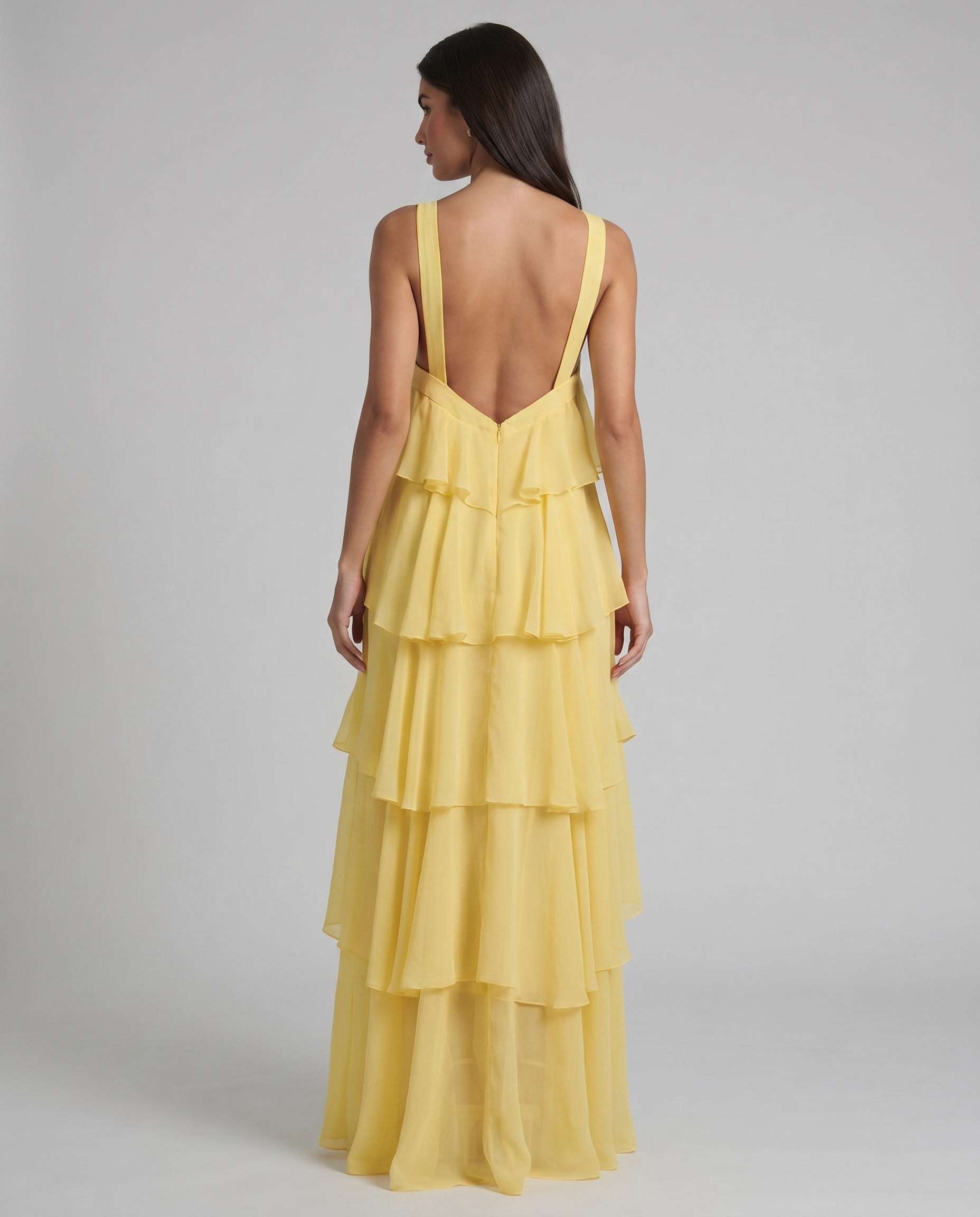 Back view yellow ruffle maxi dress with low V-back straps, center zipper, and layered tiers