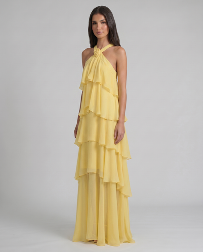 Three-quarter view yellow flower ruffle maxi dress showing draped bodice overlay and tiered hem