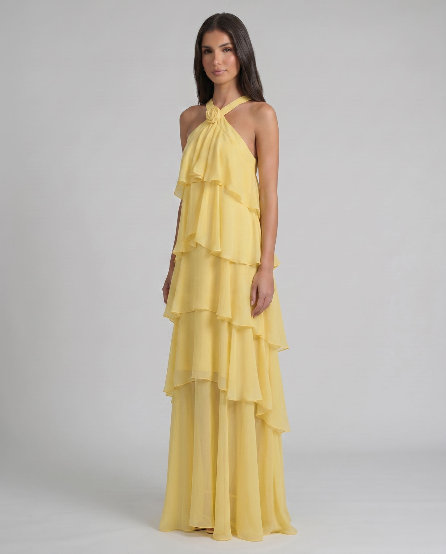 Full-length three-quarter view yellow ruffle maxi dress with layered skirt panels and halter top