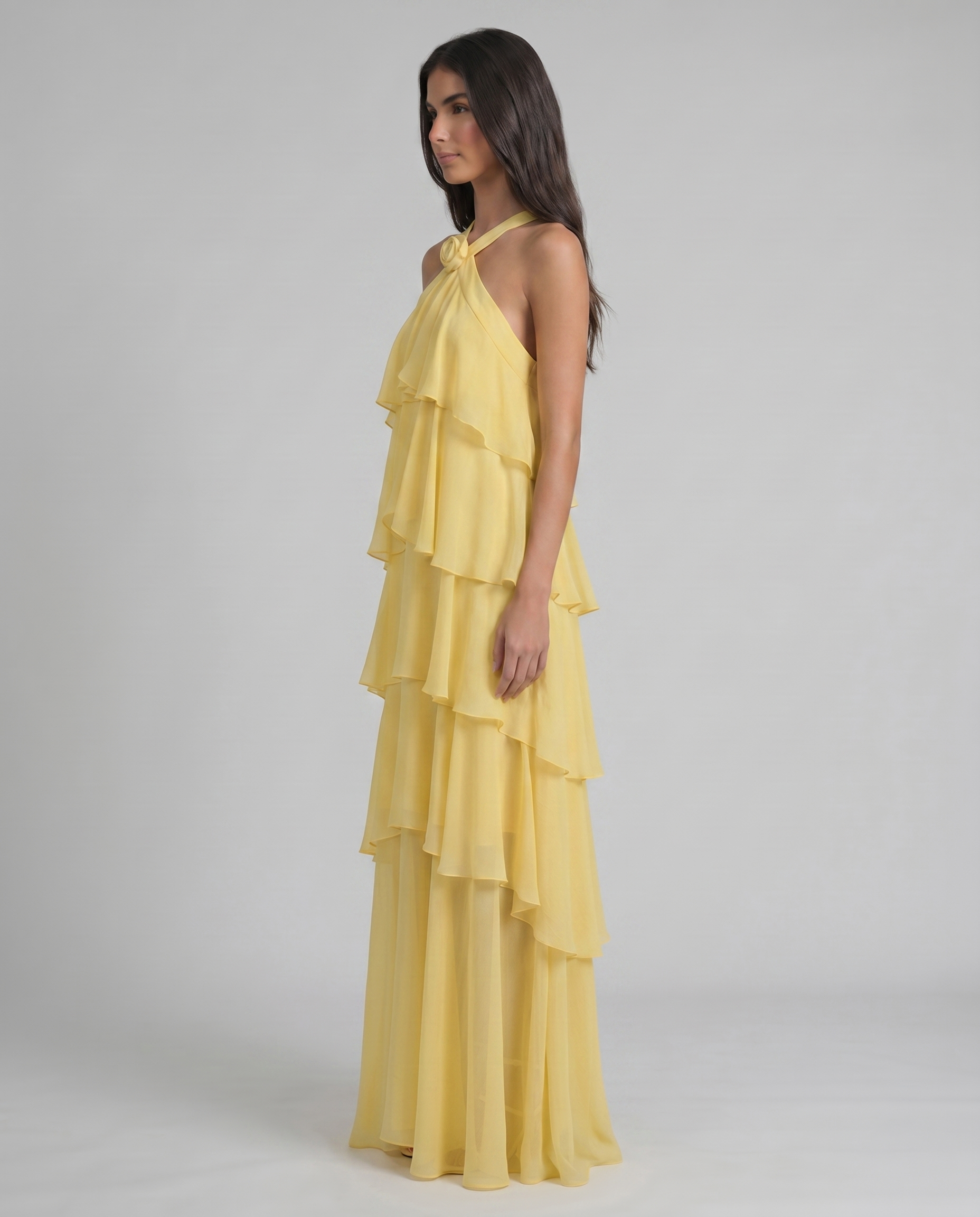 Profile view of yellow tiered ruffle maxi dress highlighting flowy chiffon skirt and halter bodice
