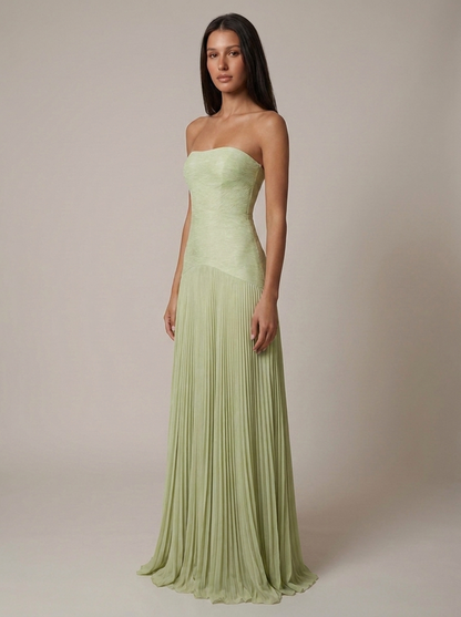 Angled front view of green forest maxi dress with asymmetrical waist seam and pleated skirt