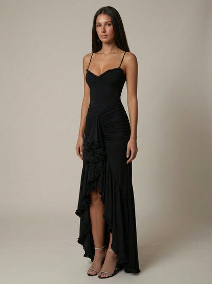 Angled front black maxi dress showing asymmetrical lace ruffle trim along slit and hem