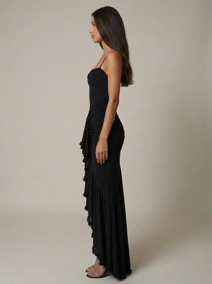 Side view black spaghetti strap maxi dress with fitted ruched silhouette and draped skirt
