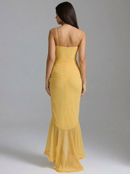 Back view of yellow maxi dress with adjustable straps, center zipper, ruched back and sheer hem
