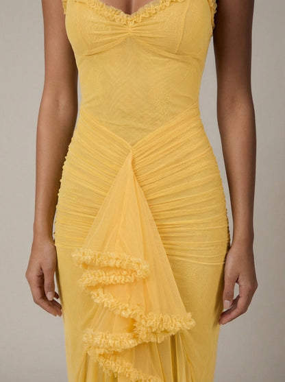 Close-up of yellow maxi dress bodice with sweetheart neckline trim, ruched waist and tulle ruffle drape