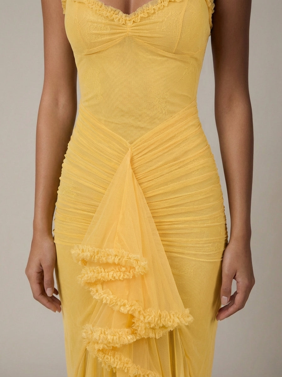 Detail shot of yellow maxi dress showing mesh fabric, gathered skirt ruching and layered ruffle accent