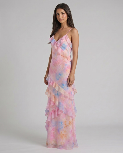 Angled front view of pink tie-dye maxi dress with asymmetrical ruffle overlay and flowy skirt