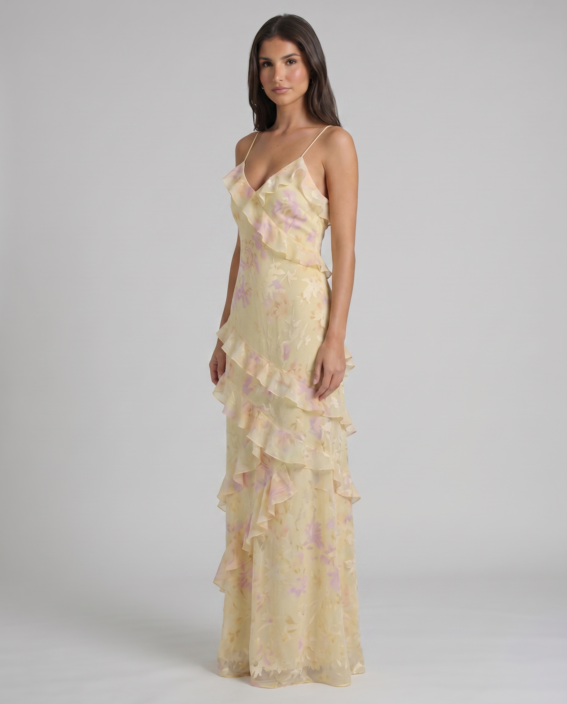 Three-quarter view yellow floral maxi dress showing cascading ruffle bodice and layered hem