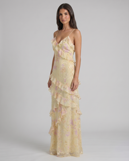 Three-quarter view yellow floral maxi dress showing cascading ruffle bodice and layered hem