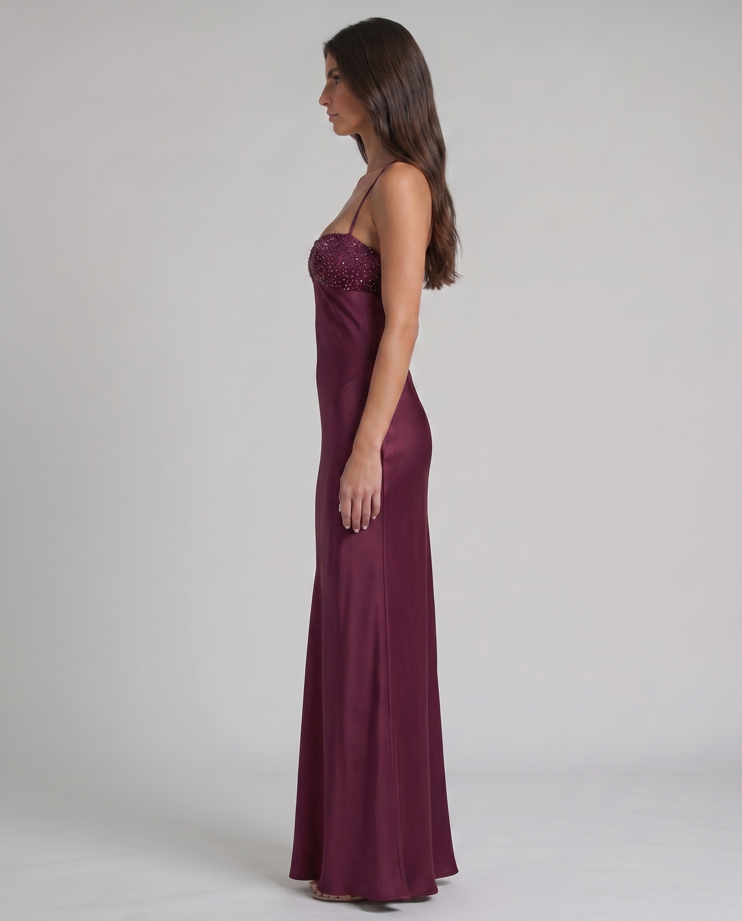 Hemline detail of purple satin maxi dress with subtle flare near the ankles and smooth drape