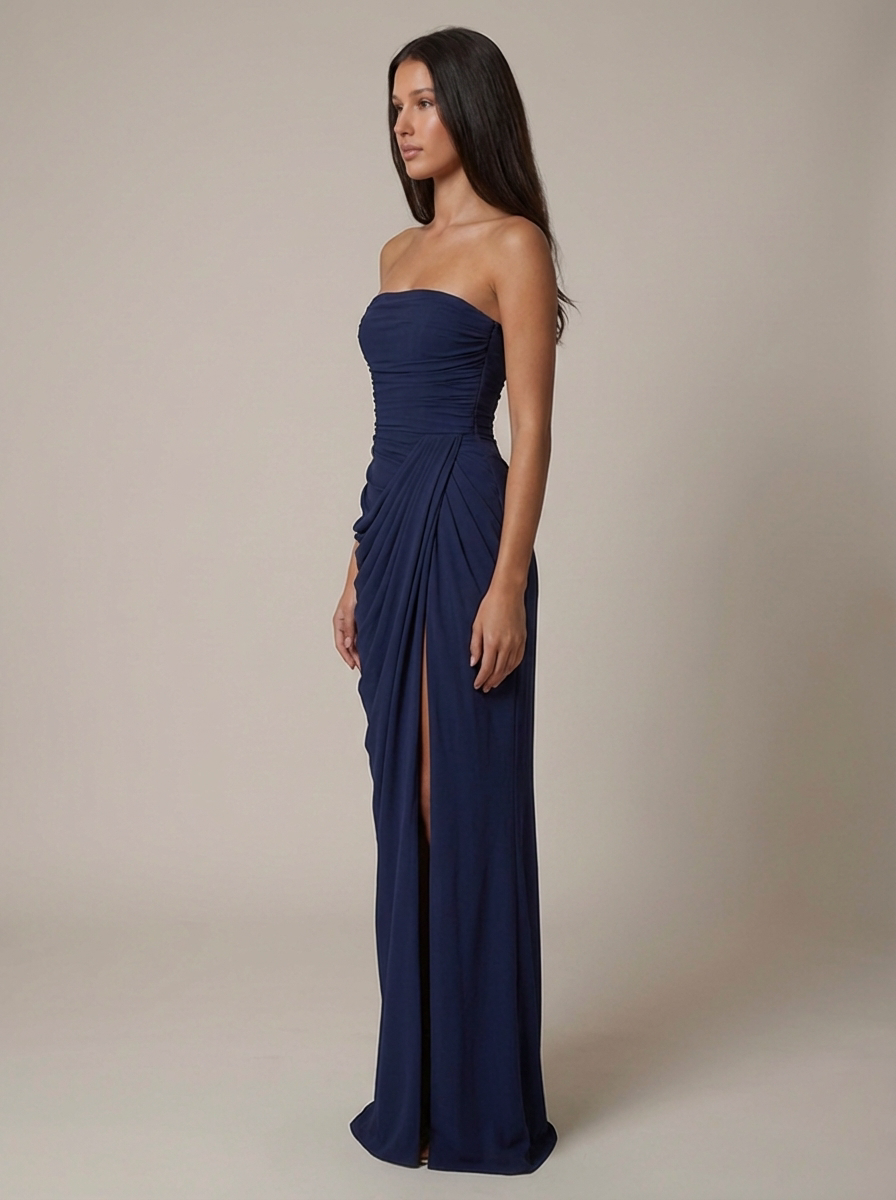 Side view navy strapless maxi dress with smooth fitted bodice, draped skirt, and front slit