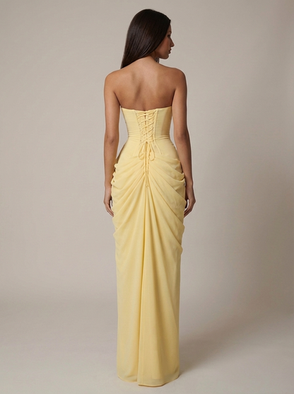 Full back shot of yellow maxi dress with corset lacing, cinched waist and draped fabric