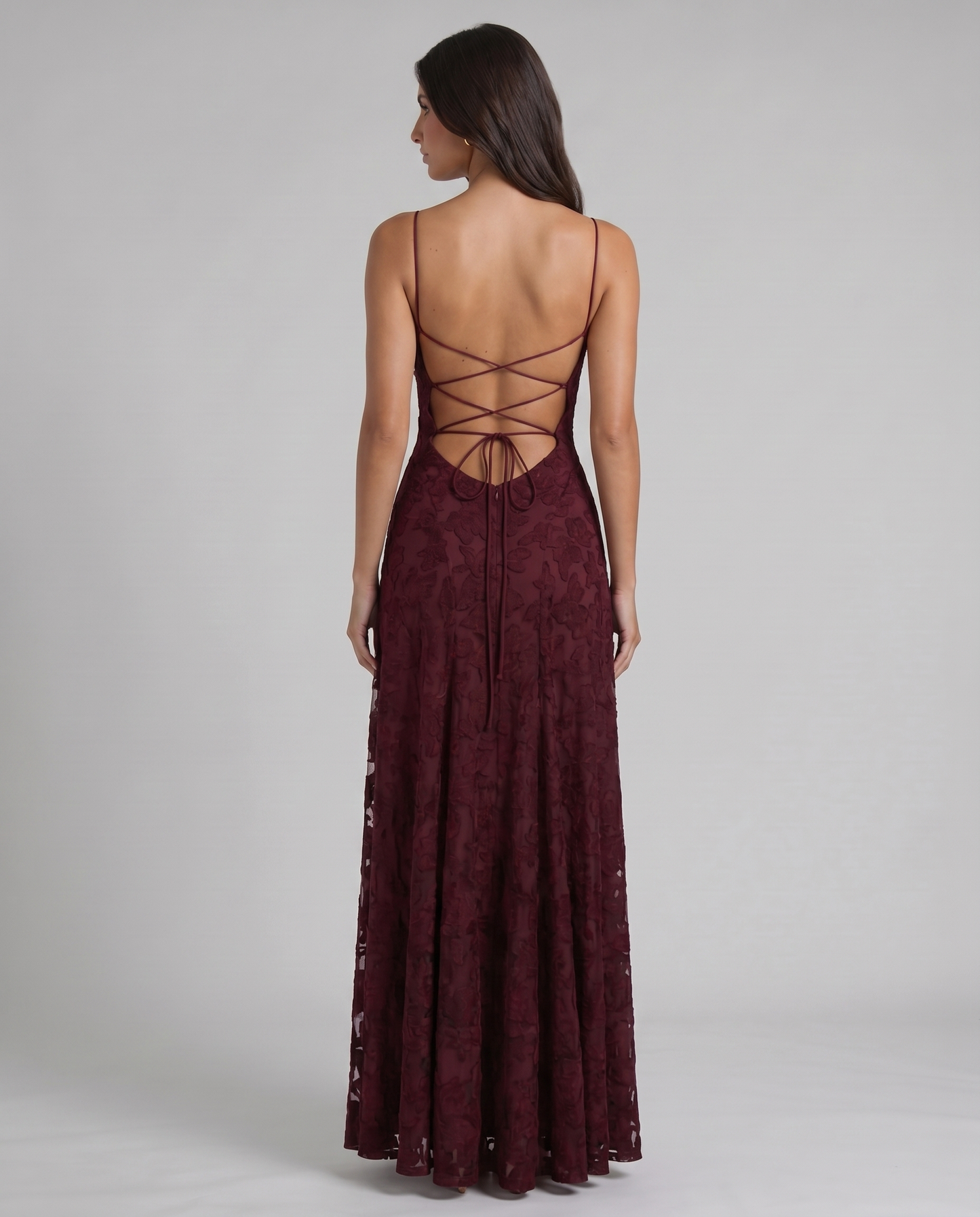 Back detail of burgundy maxi dress showing crisscross lace-up open back and tie bow