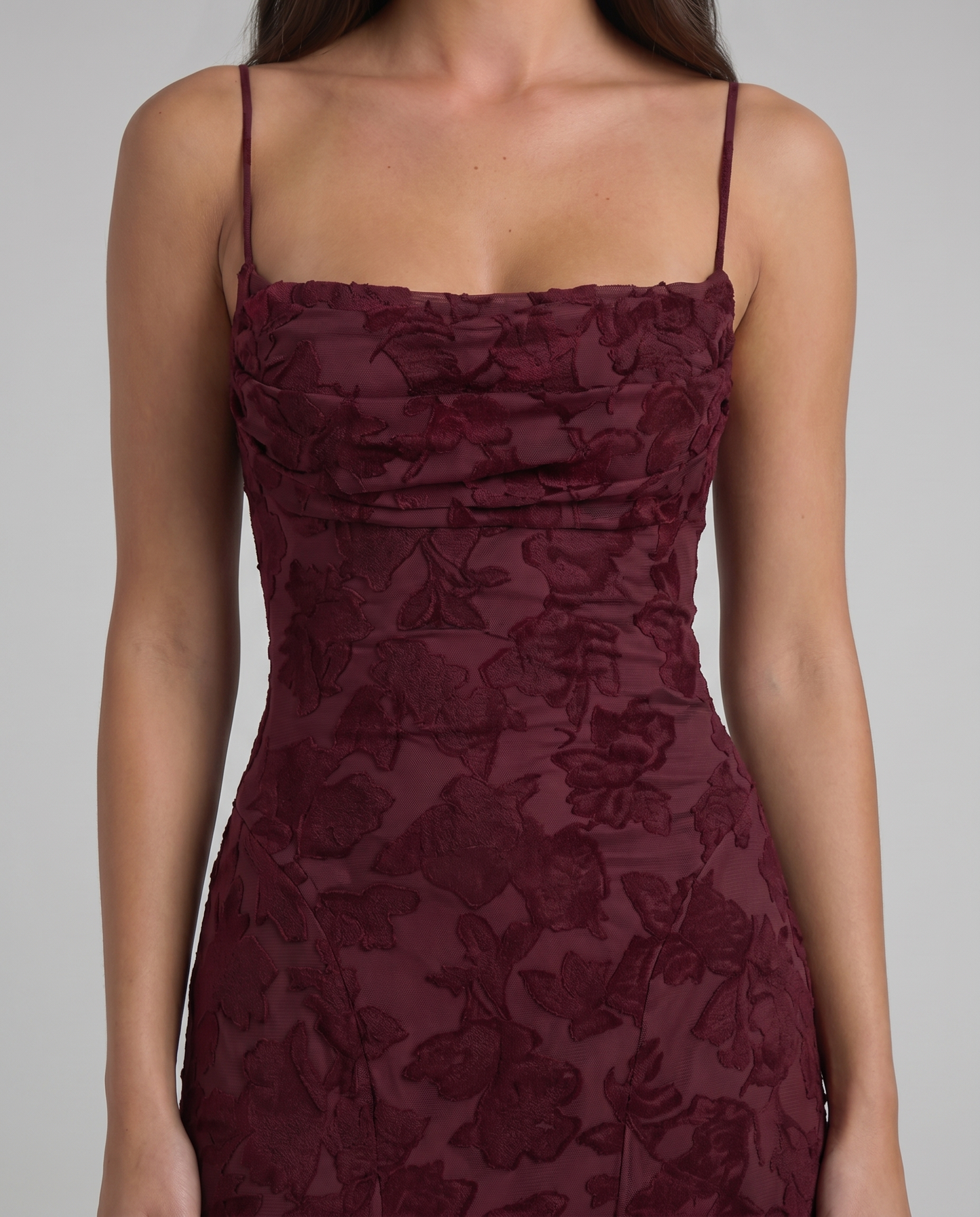 Detailed view of burgundy floral burnout fabric on fitted maxi dress with thin shoulder straps